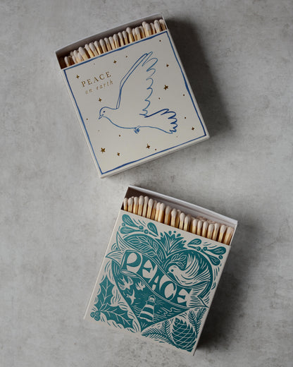 A pair of Christmas themed match boxes, each with a dove design.