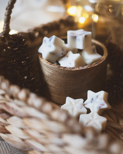 Festive scene with star-shaped white wax melts and fairy lights.