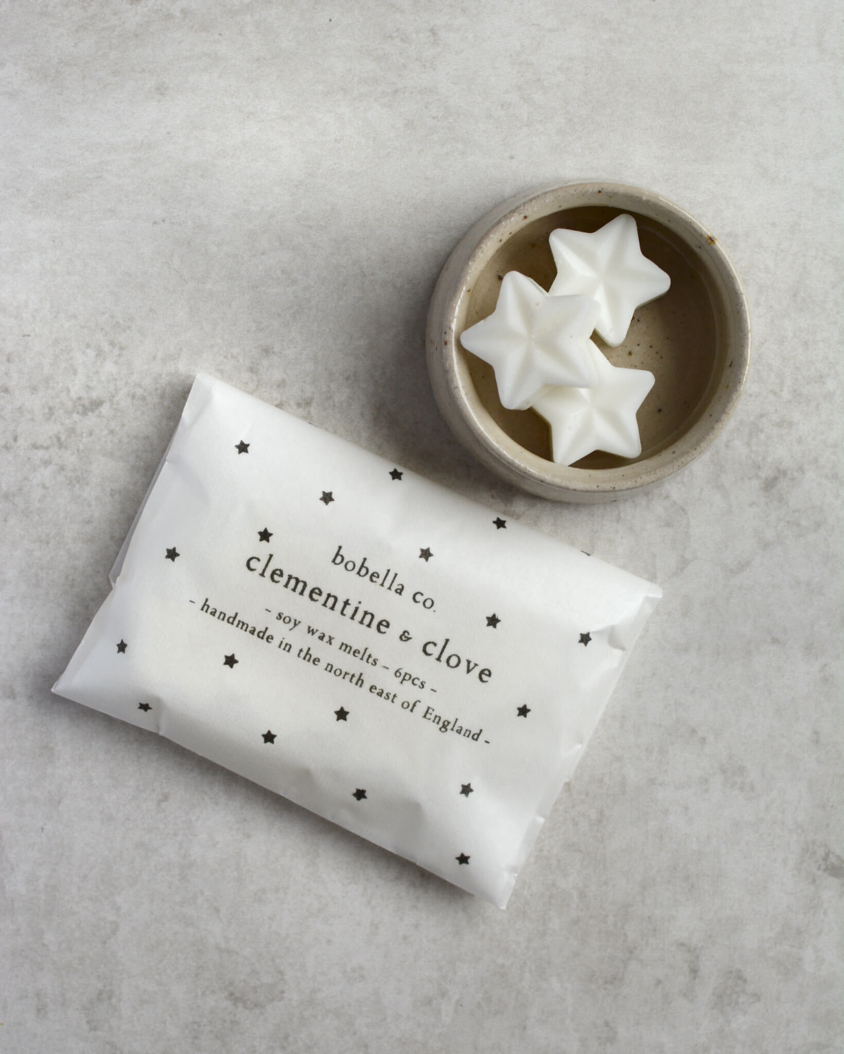 Star-shaped wax melts, next to a starry wax melt package.