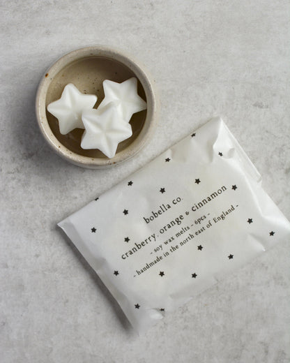 Star-shaped wax melts in a dish, next to a starry package of melts.