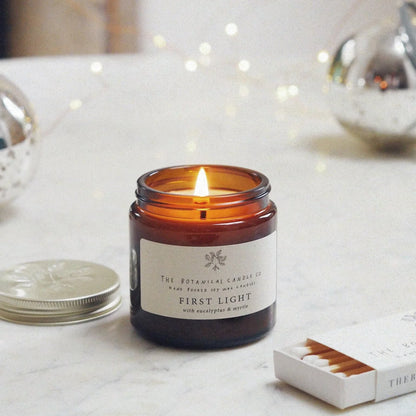 A 120ml eucalyptus and myrtle scented candle in an amber glass jar, surrounded by twinkly lights.