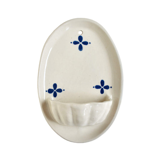 Cream and blue ceramic candle wall sconce on a white background.