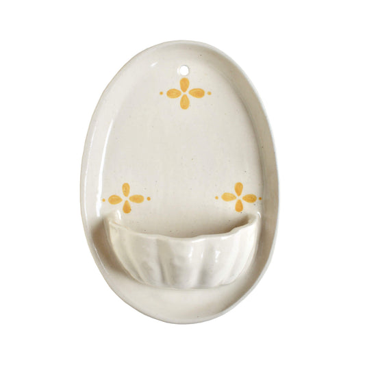 A cream and yellow ceramic wall sconce, on a white background.