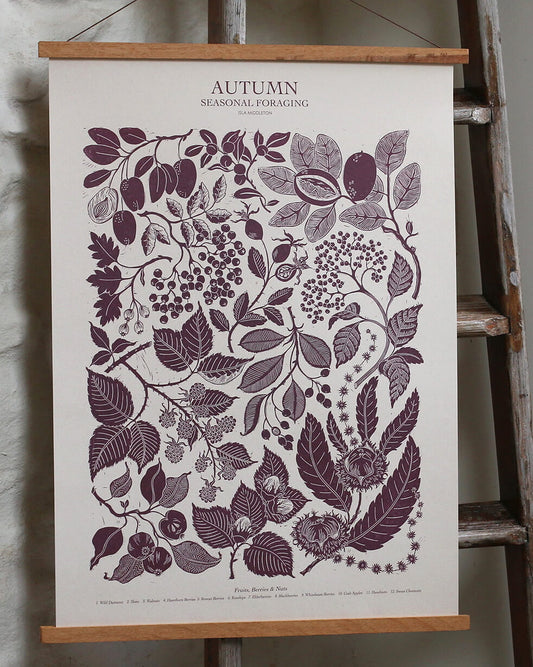 A linocut print in plum tones, depicting seasonal plants of Autumn. 