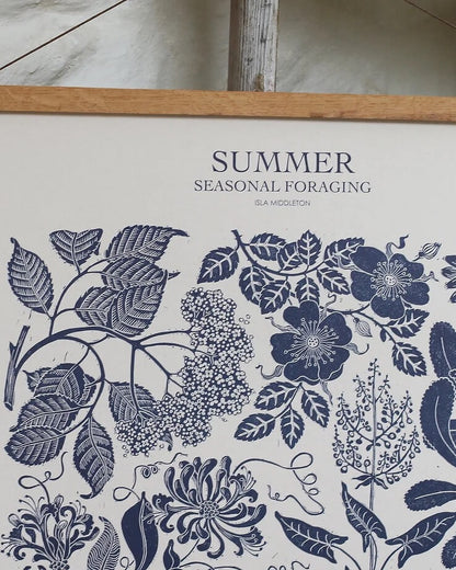 Close-up of a linocut print of summer plants in a deep inky blue.