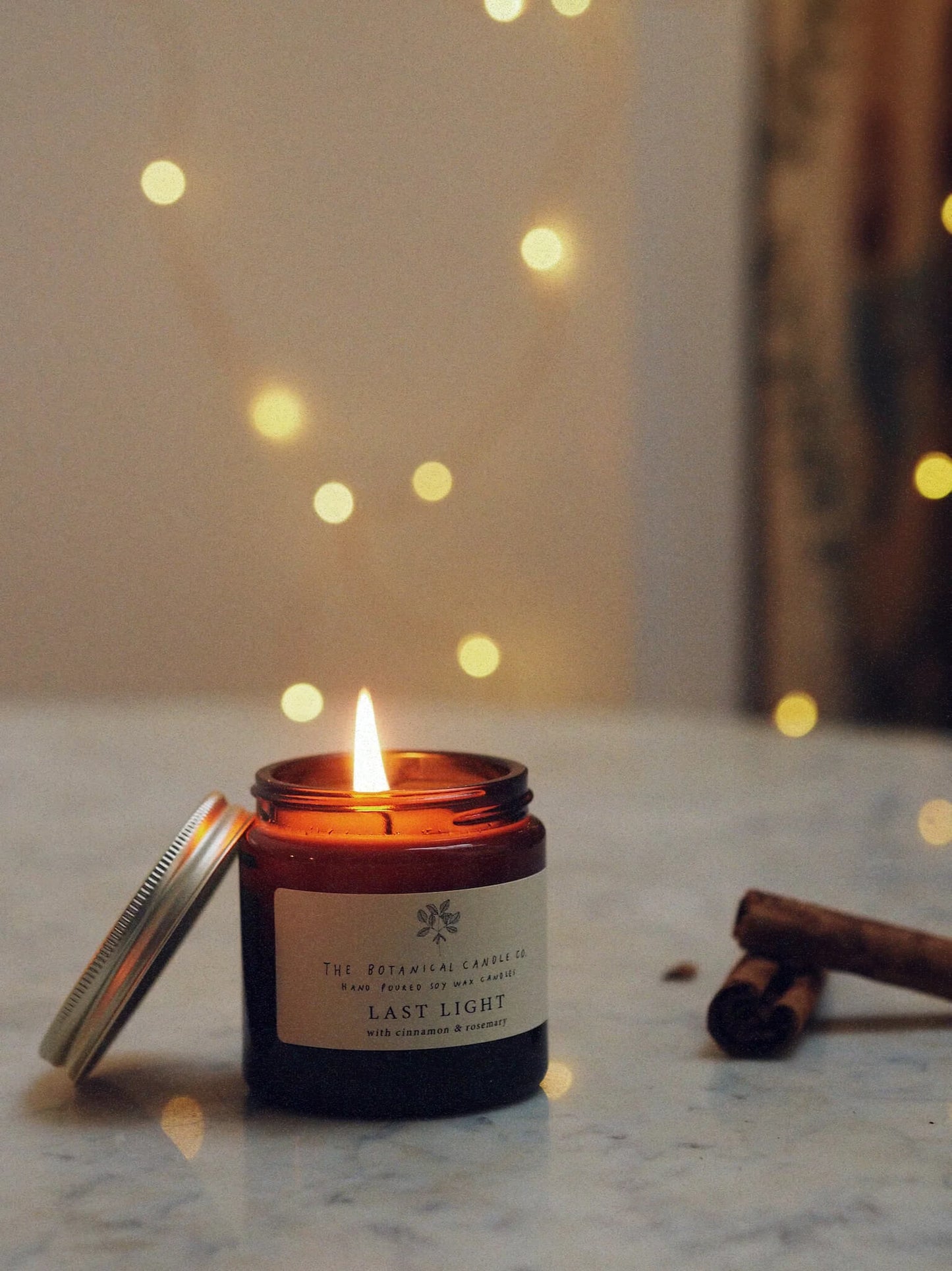 A 120ml Christmas blend scented candle in an amber glass jar, surrounded by twinkly lights.