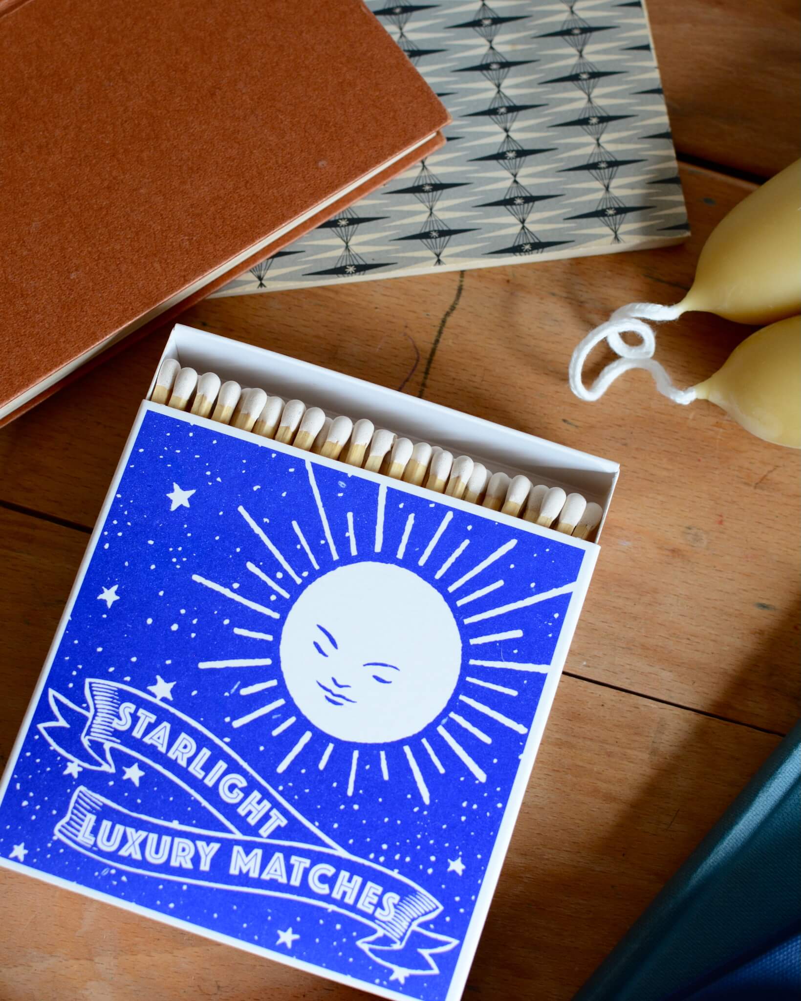 A blue box of matches, featuring a moon illustration.