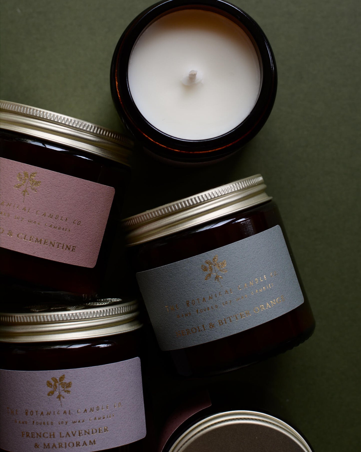 A collection of candles in amber glass jars.