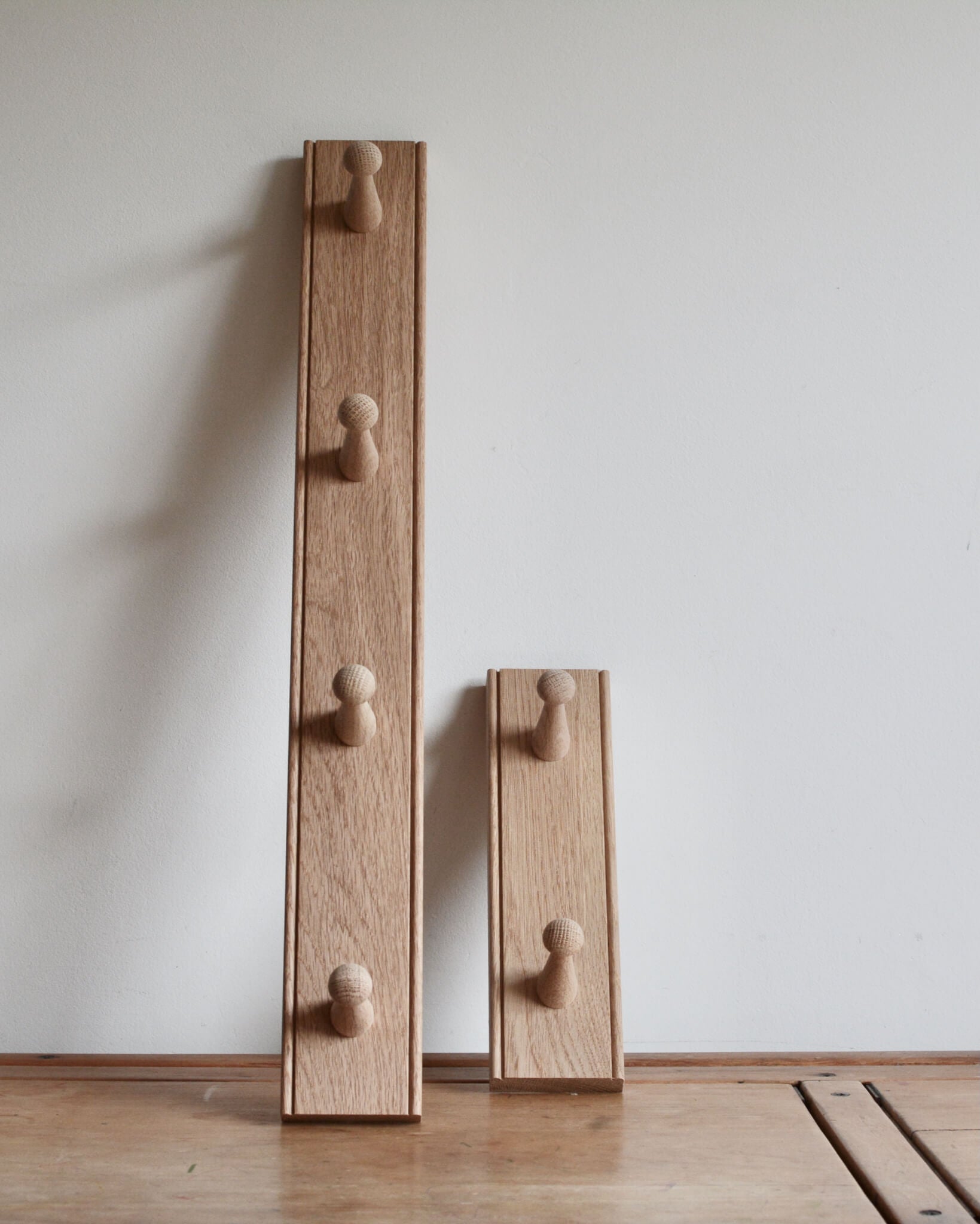 A pair oak shaker peg rail with 2 and 4 pegs.