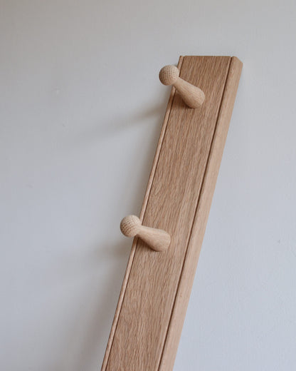 Detail shot of a 4-peg oak shaker peg rail.