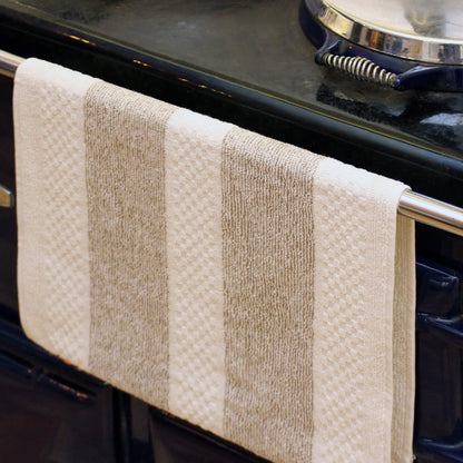 A striped kitchen towel for looping over a range oven handle.