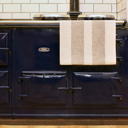 A striped kitchen towel for looping over a range oven handle.