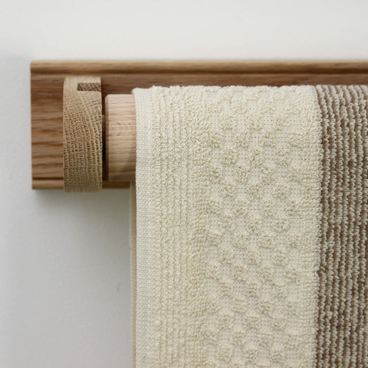 A striped kitchen towel for looping over a towel rail.