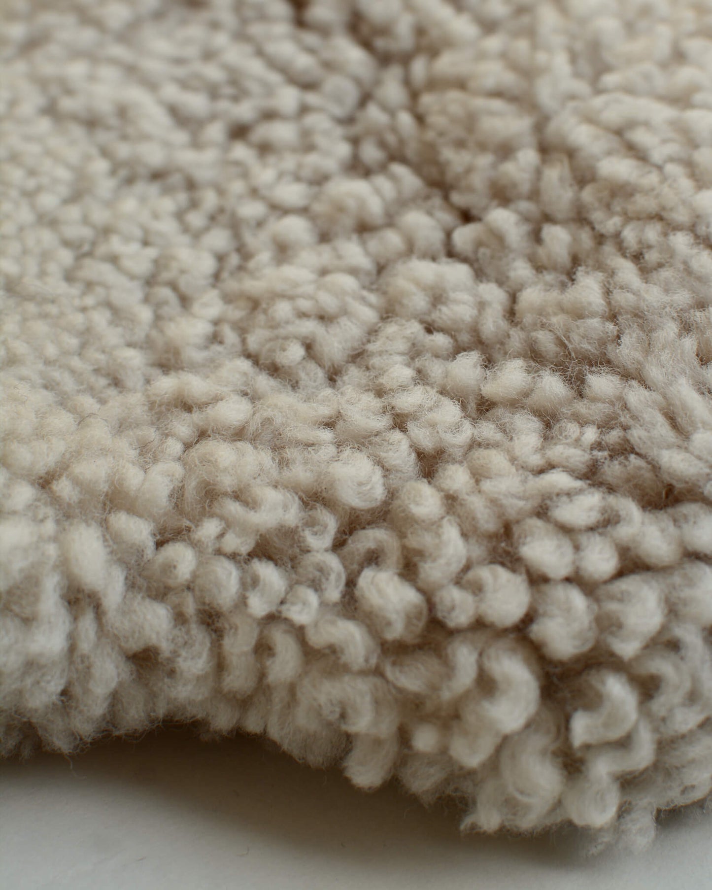 A close up of a natural sheepskin hot water bottle.