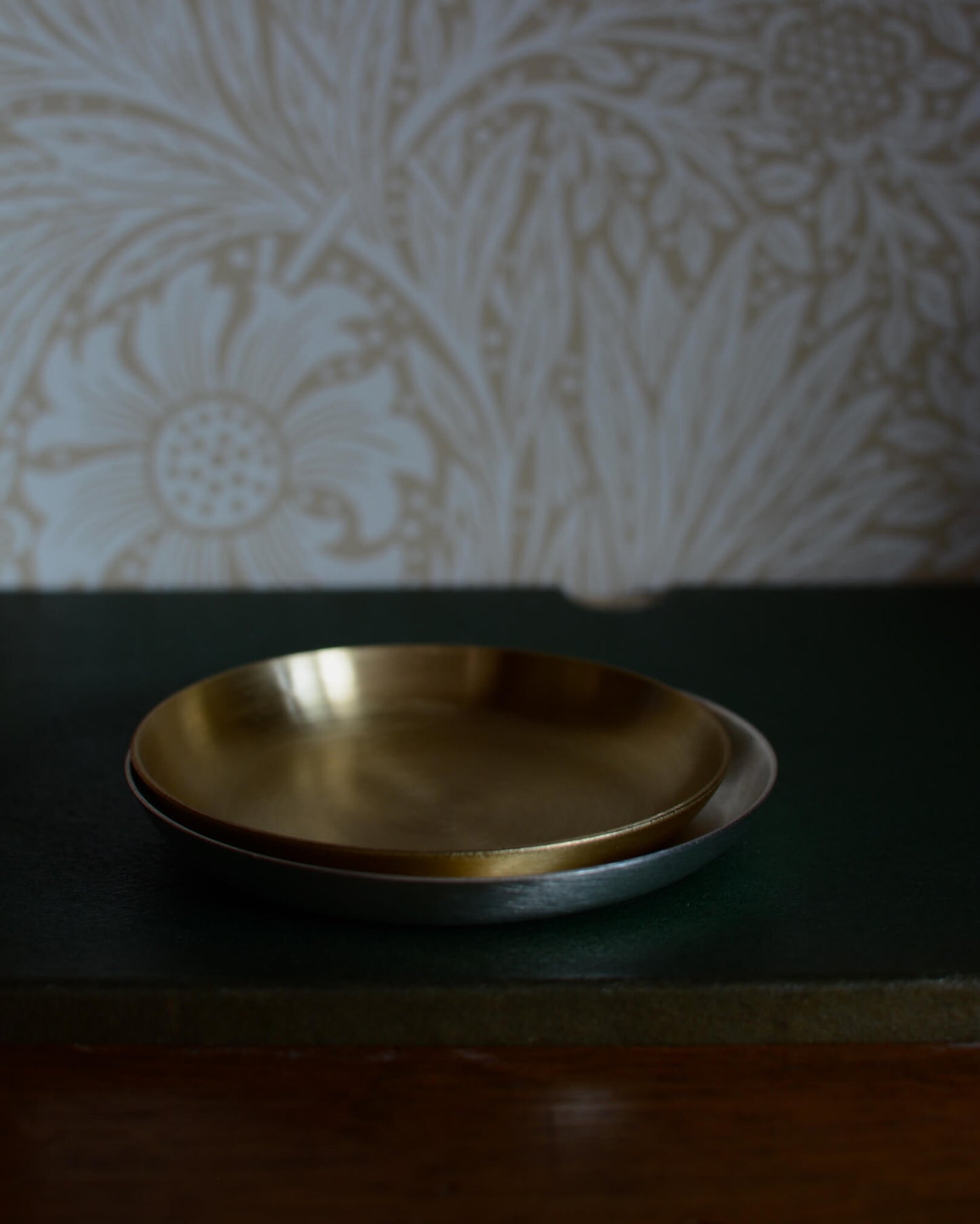 A solid brass candle dish, and a silver candle dish.