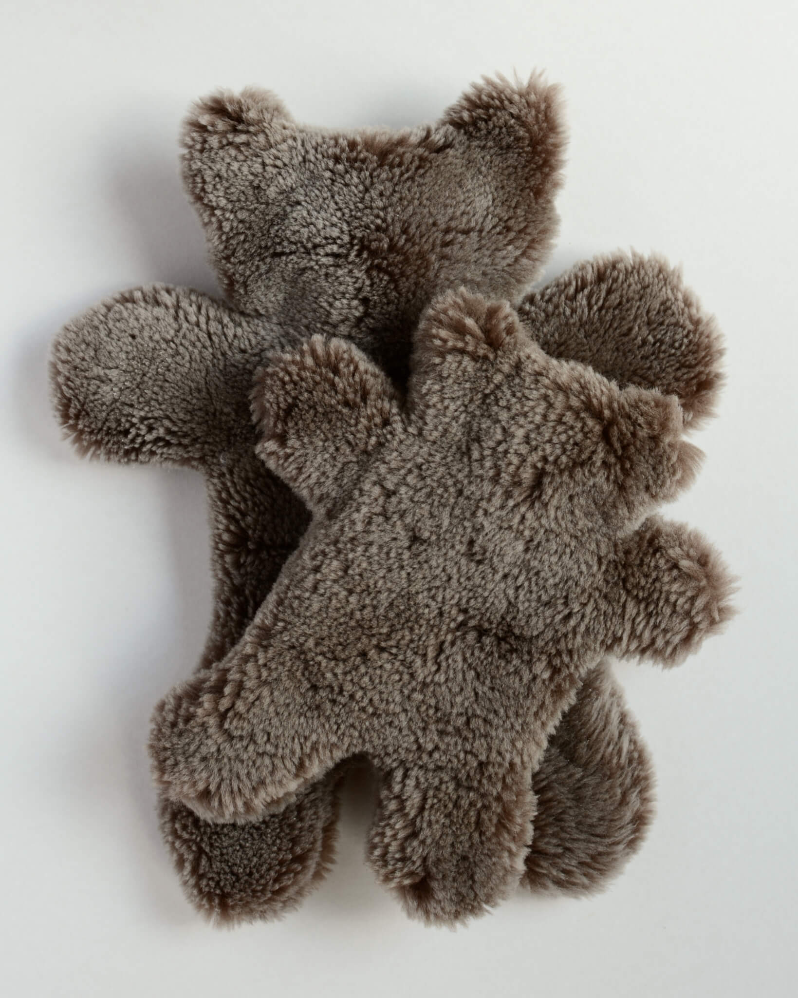 A pair of teddy bear sheepskin hot water bottles, on a white background.