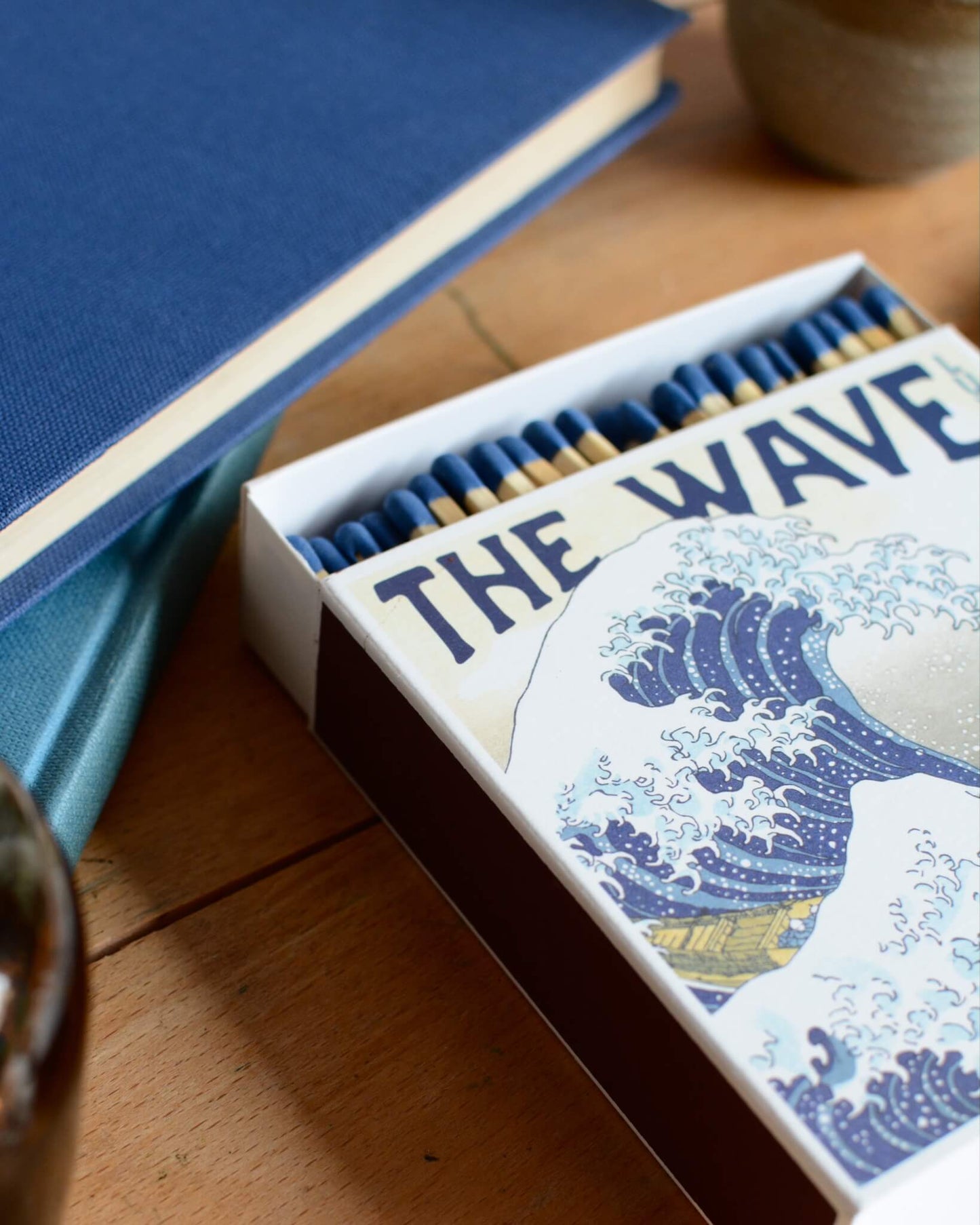 Close-up of a box of matches with a blue-tone Japanese illustration of a wave.