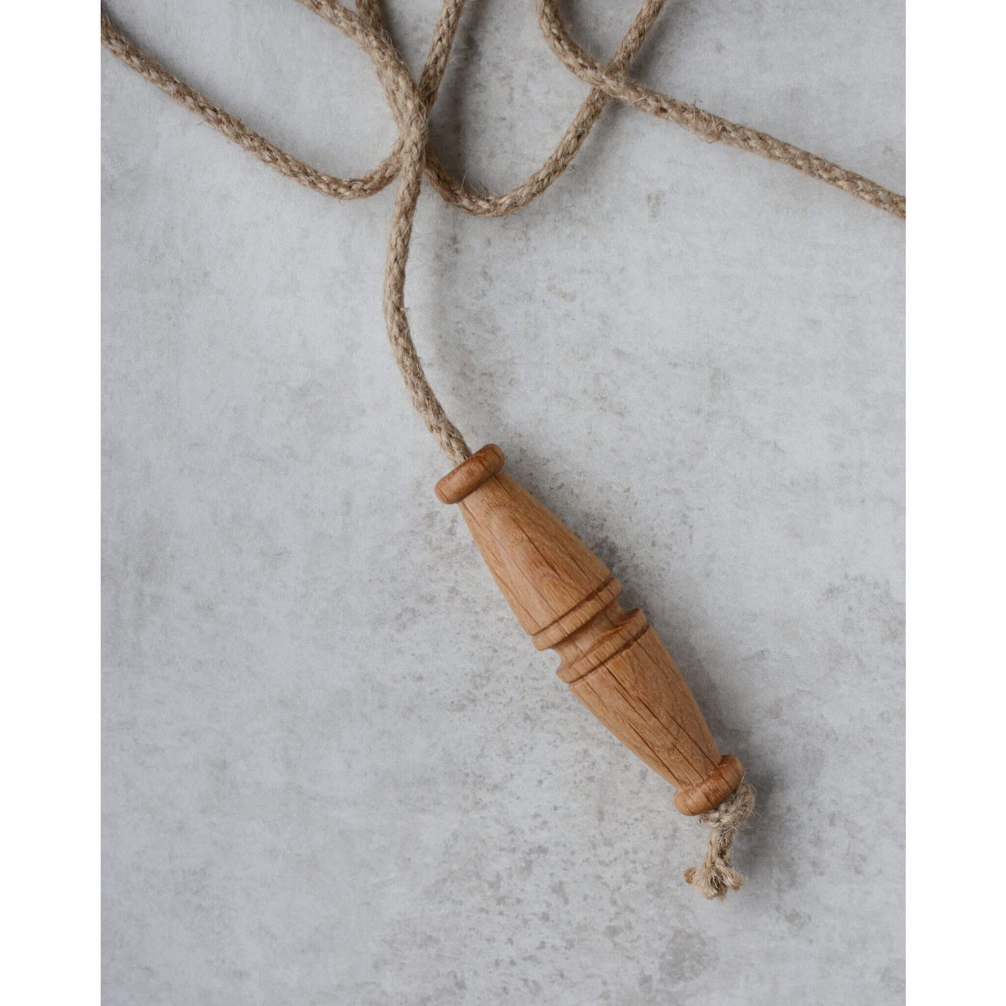 An oak light pull handle with long rope pull.