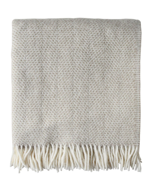 An oatmeal beehive pattern blanket on a white background.