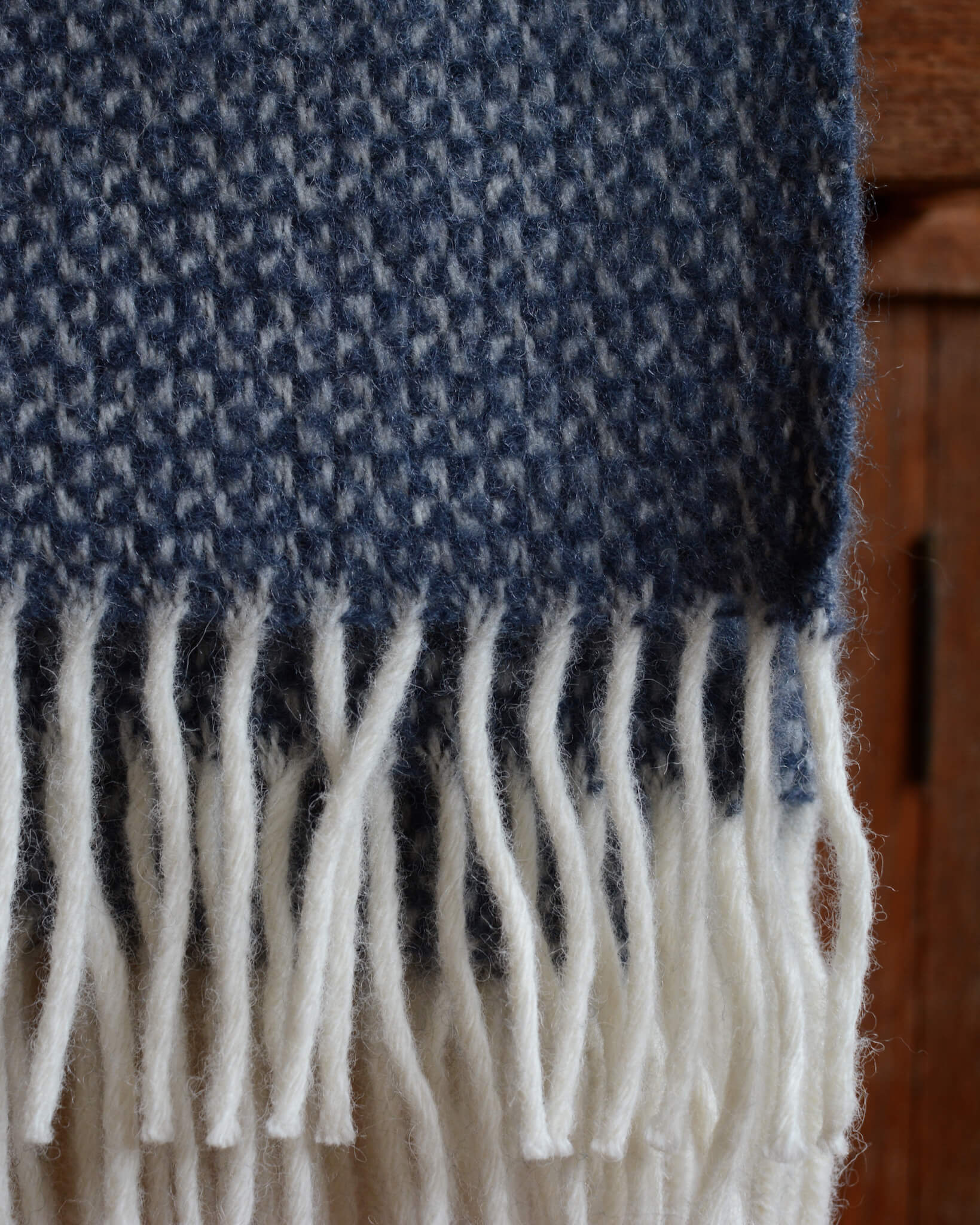 A detail shot of a blue woollen blanket with a windmill weave.