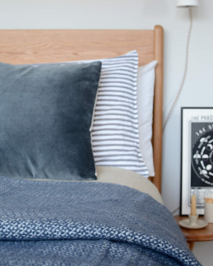 A blue woollen blanket on top of a bed.